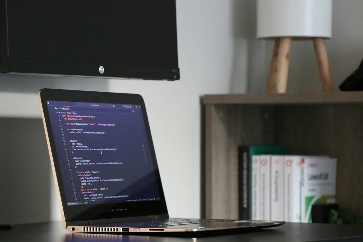 Laptop displaying source code on a desk