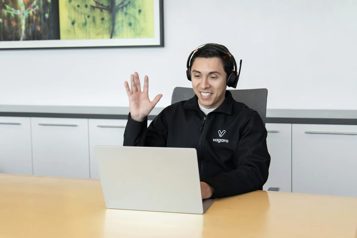 Support agent with a headset at a laptop